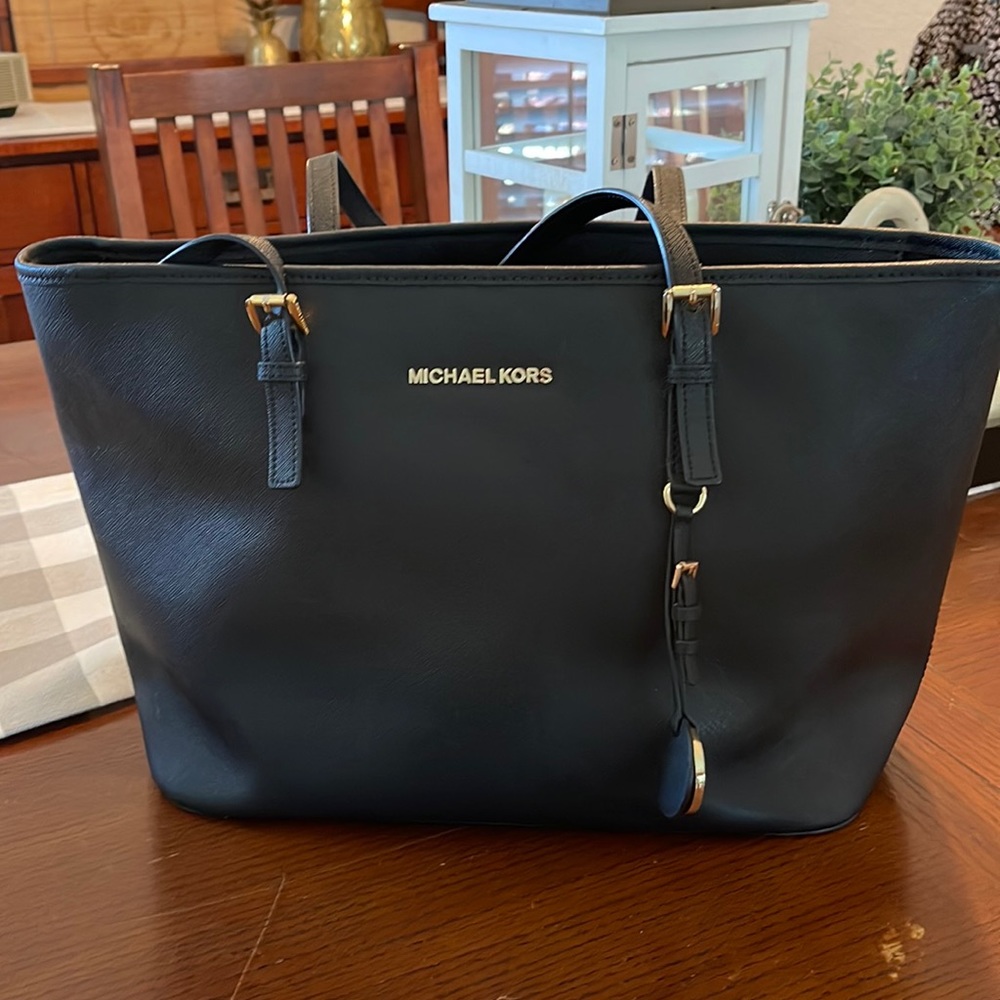 Michael Kors tote with adjustable strap. Gold accents